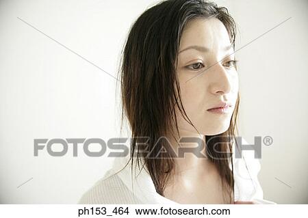 Close-up of a young woman looking away View Large Photo Image Picture - Close-up of a young woman looking away. Fotosearch