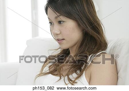 Stock Image - Close-up of a young woman looking down. Fotosearch
