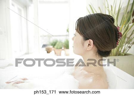 Close-up of a young woman relaxing in a bubble bath View Large Photo Image Stock Image - Close-up of a young woman relaxing in a bubble bath. Fotosearch