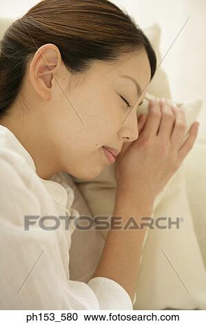 Close-up of a young woman sleeping on a couch View Large Photo Image Stock Image - Close-up of a young woman sleeping on a couch. Fotosearch