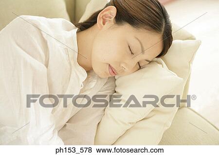 Close-up of a young woman sleeping on a couch View Large Photo Image Stock Photo - Close-up of a young woman sleeping on a couch. Fotosearch