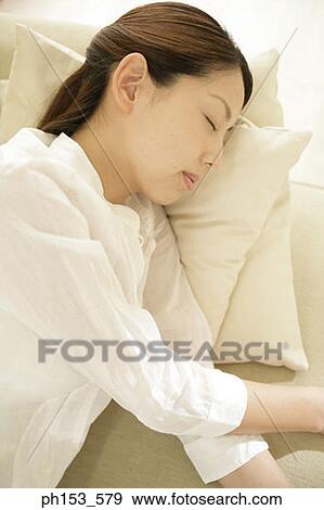 Close-up of a young woman sleeping on a couch View Large Photo Image Stock Photo - Close-up of a young woman sleeping on a couch. Fotosearch