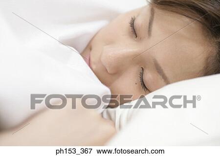 Close-up of a young woman sleeping View Large Photo Image Stock Photo - Close-up of a young woman sleeping. Fotosearch