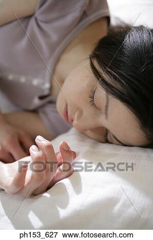 Close-up of a young woman sleeping View Large Photo Image Stock Photo - Close-up of a young woman sleeping. Fotosearch