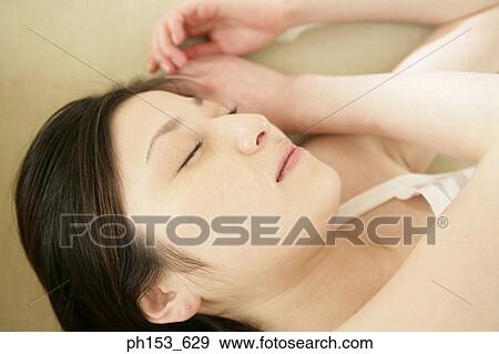 Close-up of a young woman sleeping View Large Photo Image Stock Photo - Close-up of a young woman sleeping. Fotosearch