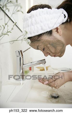 Close-up of a young woman washing her face over a bathroom sink View Large Photo Image Stock Image - Close-up of a young woman washing her face over a bathroom sink. Fotosearch