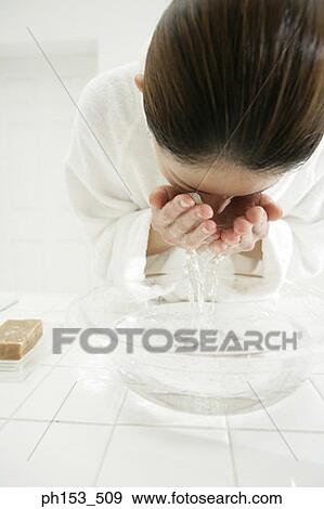 Close-up of a young woman washing her face View Large Photo Image Stock Photo - Close-up of a young woman washing her face. Fotosearch