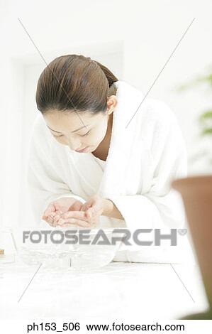 Stock Photograph - Close-up of a young woman washing her face. Fotosearch