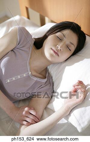 Picture - High angle view of a young woman sleeping. Fotosearch