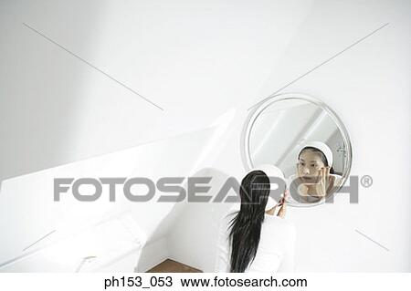 High angle view of a young woman applying moisturizer on her face View Large Photo Image Stock Image - High angle view of a young woman applying moisturizer on her face. Fotosearch