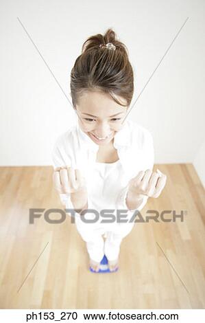 High angle view of a young woman standing on a weighing scale and making fists View Large Photo Image Stock Image - High angle view of a young woman standing on a weighing scale and making fists. Fotosearch