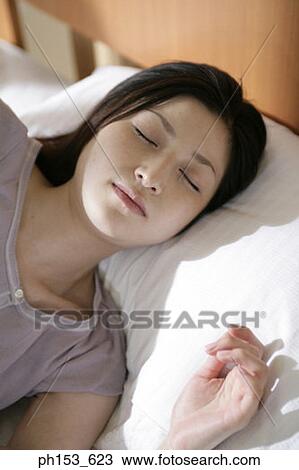 Stock Image - High angle view of a young woman sleeping. Fotosearch