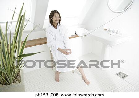 High angle view of a young woman sitting on a chair in the bathroom View Large Photo Image Stock Photo - High angle view of a young woman sitting on a chair in the bathroom. Fotosearch