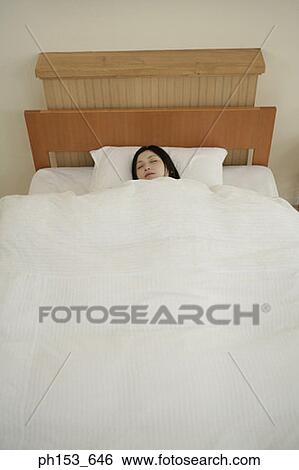 High angle view of a young woman sleeping View Large Photo Image Stock Photograph - High angle view of a young woman sleeping. Fotosearch