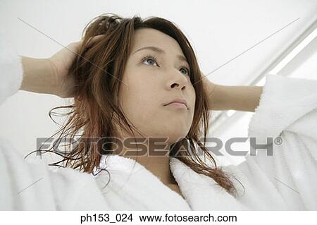 Low angle view of a young woman with her hands in her hair View Large Photo Image Picture - Low angle view of a young woman with her hands in her hair. Fotosearch