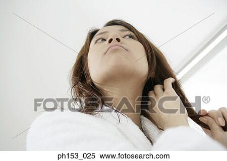 Low angle view of a young woman with her hand in her hair View Large Photo Image Stock Photography - Low angle view of a young woman with her hand in her hair. Fotosearch