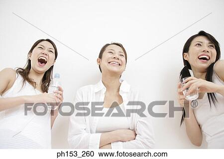 Low angle view of three young women smiling View Large Photo Image Stock Image - Low angle view of three young women smiling. Fotosearch