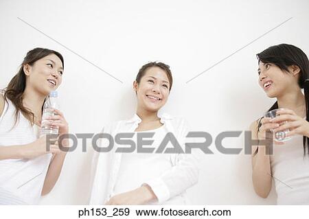 Low angle view of three young women leaning against a wall and smiling View Large Photo Image Stock Photo - Low angle view of three young women leaning against a wall and smiling. Fotosearch