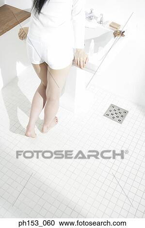 Low section view of a woman standing in front of a bathroom sink View Large Photo Image Stock Image - Low section view of a woman standing in front of a bathroom sink. Fotosearch
