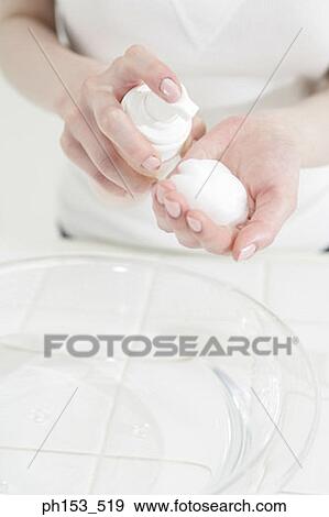 Mid section view of a woman pouring moisturizer on a cotton ball View Large Photo Image Stock Photo - Mid section view of a woman pouring moisturizer on a cotton ball. Fotosearch