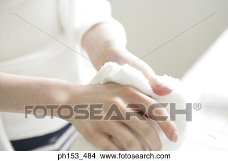 Picture - Mid section view of a young woman drying her hands. Fotosearch
