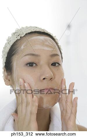 Portrait of a young woman applying soap on her face View Large Photo Image Stock Image - Portrait of a young woman applying soap on her face. Fotosearch