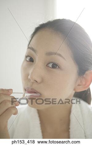 Portrait of a young woman brushing her teeth View Large Photo Image Stock Photo - Portrait of a young woman brushing her teeth. Fotosearch
