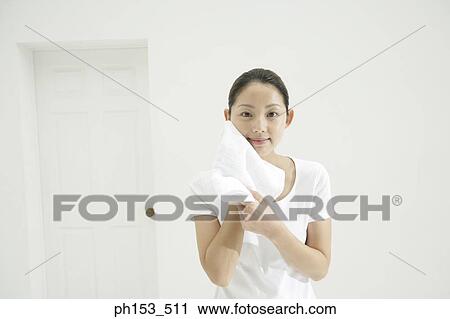 Portrait of a young woman drying her face with a towel View Large Photo Image Stock Image - Portrait of a young woman drying her face with a towel. Fotosearch