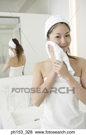 Portrait of a young woman drying her face with a towel View Large Photo Image Stock Photo - Portrait of a young woman drying her face with a towel. Fotosearch