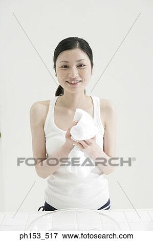 Portrait of a young woman drying her hand with a towel View Large Photo Image Stock Photo - Portrait of a young woman drying her hand with a towel. Fotosearch