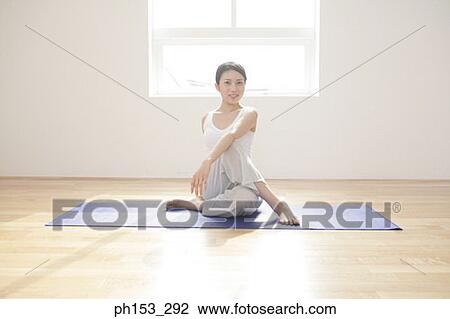Stock Image - Portrait of a young woman exercising. Fotosearch