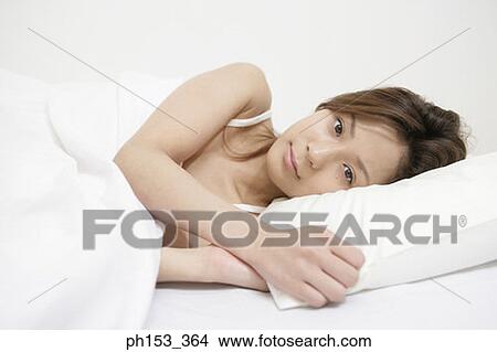 Portrait of a young woman lying on the bed View Large Photo Image Picture - Portrait of a young woman lying on the bed. Fotosearch
