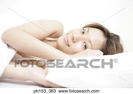 Portrait of a young woman lying on the bed View Large Photo Image Stock Image - Portrait of a young woman lying on the bed. Fotosearch