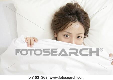 Portrait of a young woman lying on the bed View Large Photo Image Stock Photo - Portrait of a young woman lying on the bed. Fotosearch