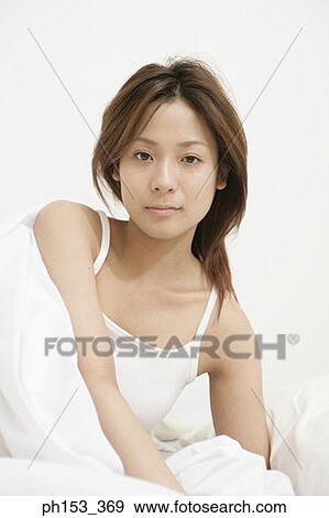 Portrait of a young woman reclining on the bed View Large Photo Image Stock Photo - Portrait of a young woman reclining on the bed. Fotosearch