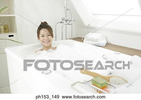 Portrait of a young woman relaxing in a bathtub and smiling View Large Photo Image Stock Photo - Portrait of a young woman relaxing in a bathtub and smiling. Fotosearch