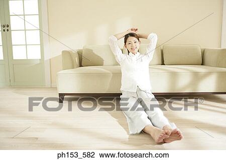 Portrait of a young woman sitting on the floor and smiling View Large Photo Image Stock Image - Portrait of a young woman sitting on the floor and smiling. Fotosearch