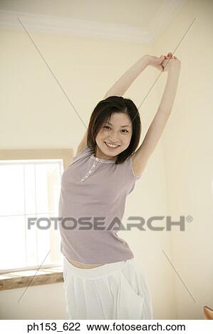 Portrait of a young woman smiling and stretching her arms View Large Photo Image Stock Image - Portrait of a young woman smiling and stretching her arms. Fotosearch