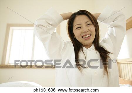 Stock Photograph - Portrait of a young woman stretching her arms. Fotosearch