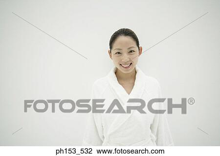 Stock Image - Portrait of a young woman wearing a bathrobe and smiling. Fotosearch