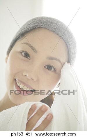 Portrait of a young woman wiping her forehead with a towel View Large Photo Image Stock Image - Portrait of a young woman wiping her forehead with a towel. Fotosearch