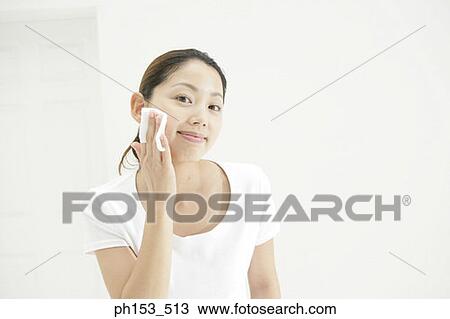 Portrait of a young woman wiping her face with a cotton pad View Large Photo Image Stock Image - Portrait of a young woman wiping her face with a cotton pad. Fotosearch