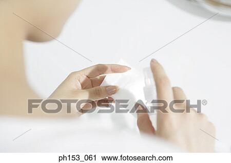 Rear view of a woman spraying facial cleanser on a tissue paper View Large Photo Image Stock Image - Rear view of a woman spraying facial cleanser on a tissue paper. Fotosearch