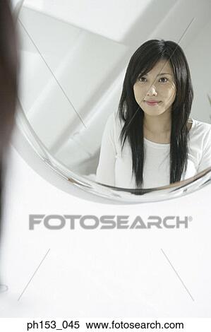 Reflection of a young woman in a mirror View Large Photo Image Stock Photography - Reflection of a young woman in a mirror. Fotosearch