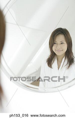 Reflection of a young woman smiling in a mirror View Large Photo Image Stock Photograph - Reflection of a young woman smiling in a mirror. Fotosearch