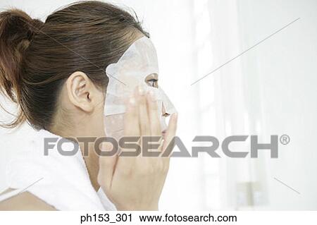 Side profile of a young woman applying a facial mask View Large Photo Image Stock Image - Side profile of a young woman applying a facial mask. Fotosearch
