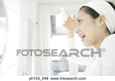 Side profile of a young woman holding a tissue paper in front of a mirror View Large Photo Image Stock Photo - Side profile of a young woman holding a tissue paper in front of a mirror. Fotosearch