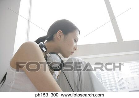 Side profile of a young woman sitting beside a window View Large Photo Image Stock Image - Side profile of a young woman sitting beside a window. Fotosearch