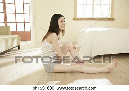 Side profile of a young woman sitting on the floor View Large Photo Image Stock Image - Side profile of a young woman sitting on the floor. Fotosearch