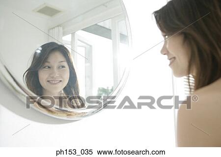 Side profile of a young woman smiling in front of a mirror View Large Photo Image Stock Photography - Side profile of a young woman smiling in front of a mirror. Fotosearch